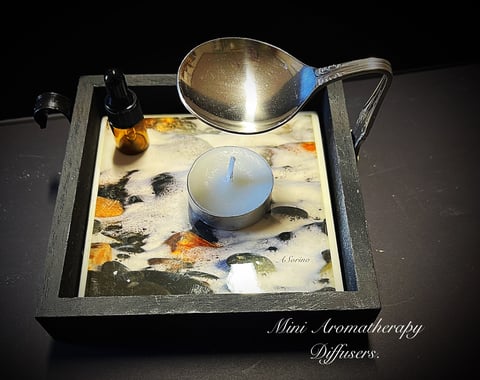 Mini Aromatherapy Diffuser with a metal spoon above a decorative tray containing a candle and dried flowers